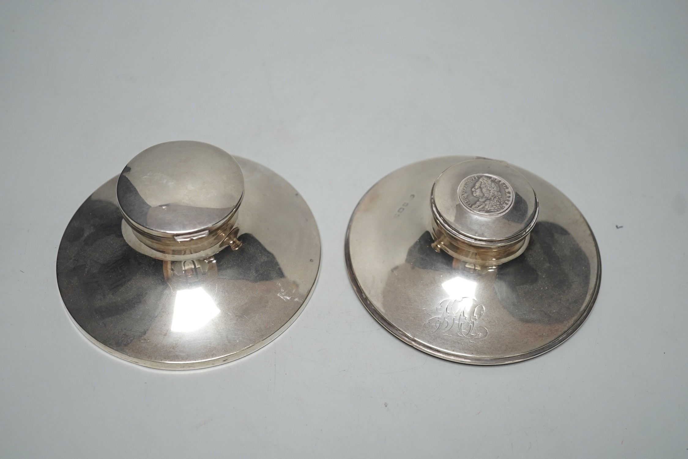 A George V silver mounted capstan inkwell, by Mappin & Webb, London, 1916, diameter 13.6cm and one other silver mounted capstan inkwell.